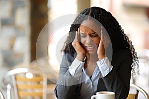 Black businesswoman suffering migraine in a bar
