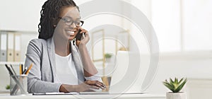Black Businesswoman Talking On Cellphone And Using Laptop In Office, Panorama