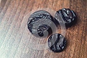 Black buttons on wooden background