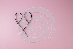 Black cable tie on pink background