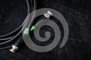 Black cable for transferring sdi signal through bnc connector on a dark background