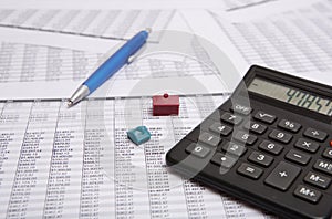 Black calculator, pen, small house