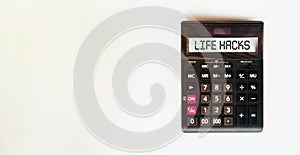 Black calculator with text Life Hacks on the white background