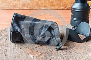 Black camera lens bag on wood