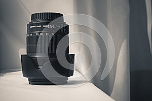 Black camera zoom lens on white cloth
