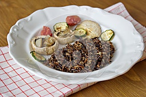 Black canadian rice served with mushrooms, tomatoes and zucchini