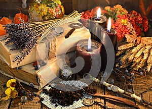 Black candles, old books, lavender flowers and magic objects on witch table