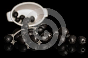 Black canned olive isolated on black glass