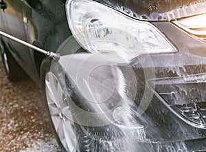 Black car cleaning with lots of foam.