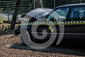 Black car drives head-on against tree