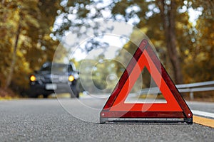 Black car have accident park on road. Red triangle, red emergency stop sign, red emergency symbol and black car stop and park on