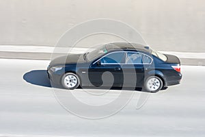 Black car in motion with blurred background