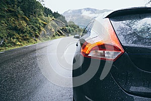 Black car riding mountain foggy road in Norway