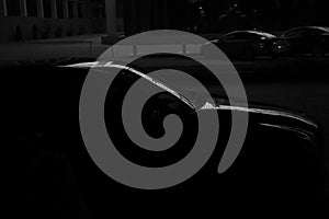 Black car standing at night parking. modern brandless cars. Transportation. Luxury car fleet consisting. neon light reflection on