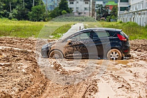 The black car stuck in the mud.