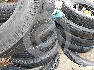 Black car tires piled on the beach