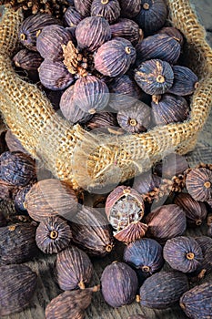 Black cardamom pods with open shell in gunny bag.