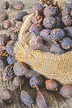 Black cardamom pods with open shell in gunny bag.