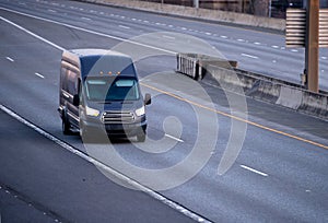 Black cargo mini van running on the multiline road