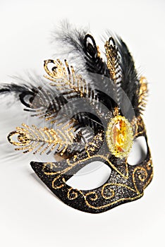 Black carnival mask with gold elements and black feathers