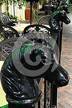 Black cast iron horse head posts on outdoor cafe patio railing