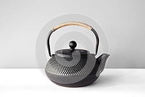 Black cast iron teapot on a white background.