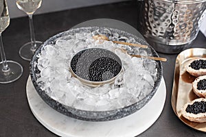 Black caviar in can on ice, caviar sandwich