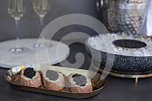 Black caviar in can on ice, caviar sandwich