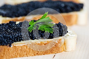 Black caviar on a slice of bread with parsley