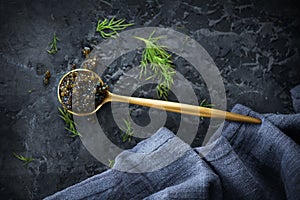 Black Caviar in a spoon on dark background. High quality real natural sturgeon black caviar close-up. Delicatessen