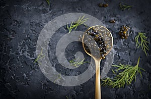 Black Caviar in a spoon on dark background. High quality real natural sturgeon black caviar close-up. Delicatessen