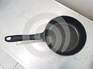 black ceramic frying pan on a stainless table