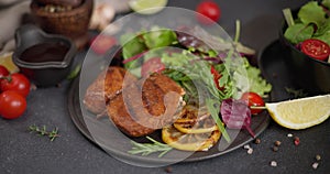 Black ceramic plate with Fried grilled pieces of Organic Tuna Steak and salad