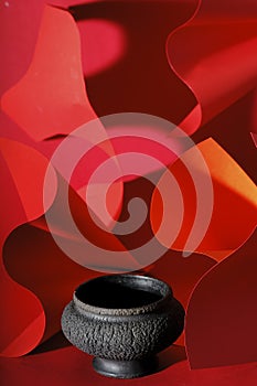 Black ceramic vase on abstract red background