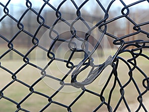 Black Chain Link Fence at a Ballpark that`s been Vandalized