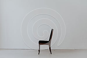 Black chair in an empty white interior room