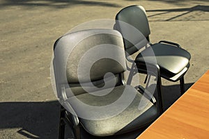 Black chairs stand outside. Office furniture in black