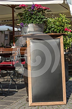 Black chalkboard stand on wood for a restaurant menu in the street