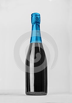 Black Champagne bottle isolated with color blue hood for label concept.