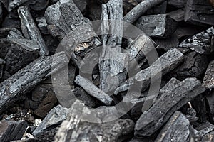 Black charcoal texture background. Natural wood charcoal, traditional charcoal or hard wood charcoal. Pile of charcoal. Details on