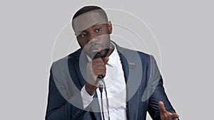 Black cheerful businessman talking in microphone.