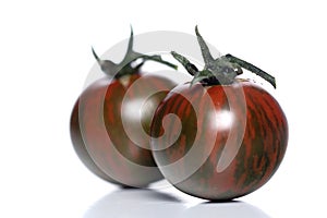 Black cherry tomatoes on white background