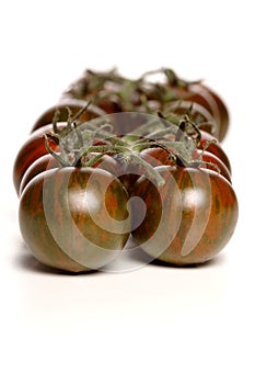 Black cherry tomatoes on white background