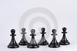 Black chess pawn figures isolated on white background.