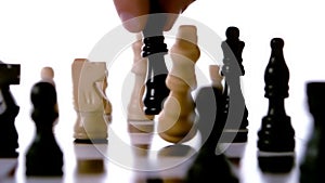 Black chess piece knocking over white