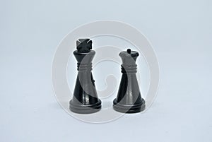 Black chess pieces all together arranged randomly on white background.