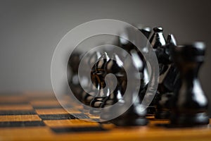 Black chess pieces on a chessboard. Selective focus. Focus on the pawn. Strategy. Sport. Business.