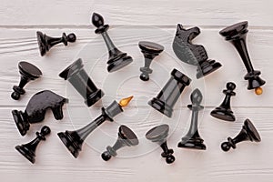 Black chess pieces lying on white background.