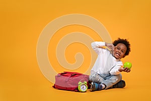 Black child boy 3 years, Student kid holding green apple in his hand and thinking point to head while sitting with school bag and