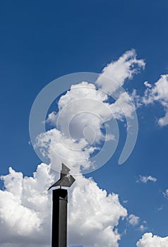 Black chimney silhouetted against a blue sky